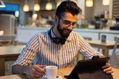 Fırının içinde gülümseyen sakallı yakışıklı bir adamın portresi.