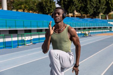 Afrikalı sporcu atletizm pistinde ısınma egzersizleri yapıyor.