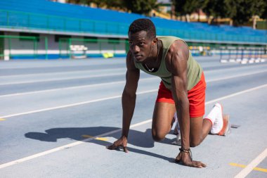 Afrikalı koşucu atletizm pistinde başlangıç pozisyonunda