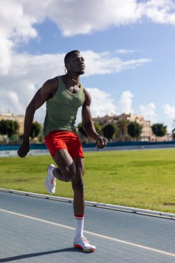 Atletizm pistinde koşan Afrikalı bir adam