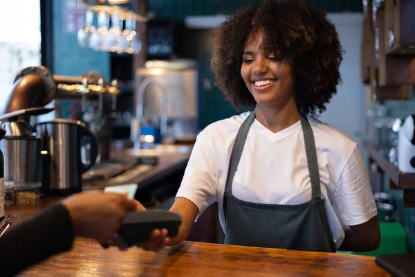 Young African waitress getting paid