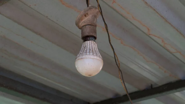 A light bulb on a metal roof outside in the dust. High quality photo