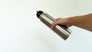 Thermos in hand on white background. High quality photo