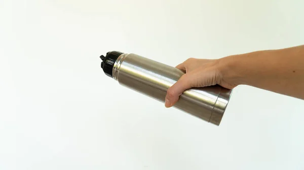 The metal thermos in your hand pours . High quality photo