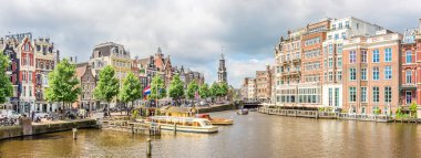 AMSTERDAM, NETHERLANDS - 23 Mayıs 2024 - Amsterdam 'da teknelerle Amstel nehrine bakın. Amsterdam Hollanda 'nın başkentidir..