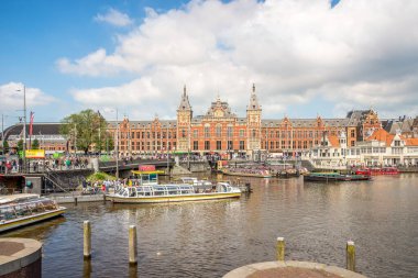AMSTERDAM, NETHERLANDS - Mayıs 23. 2024 - Amsterdam sokaklarındaki Merkez İstasyon binasına bakın. Amsterdam Hollanda 'nın başkentidir..