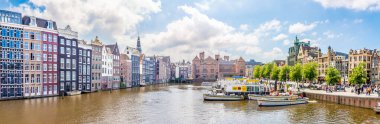 AMSTERDAM, NETHERLANDS - 23 Mayıs 2024 - Amsterdam 'ın merkezindeki Amstel nehrindeki gezi teknelerinde panoramik manzara. Amsterdam Hollanda 'nın başkentidir..