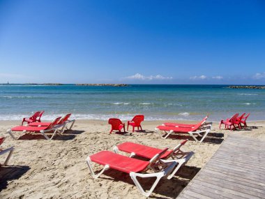 Netanya, İsrail 'in görkemli kumlu plajında sandalyeler ve dinlenme yerleri. Akdeniz kıyıları güneşli bir günde