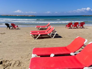 Netanya, İsrail 'in görkemli kumlu plajında sandalyeler ve dinlenme yerleri. Akdeniz kıyıları güneşli bir günde