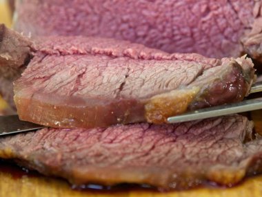 Biftek, bıçak ve çatalla orta pişmiş, dilimlenmiş, seçici odaklanmış.