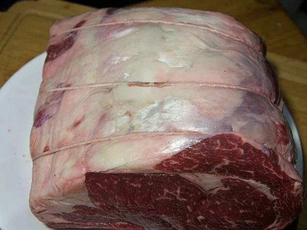 Beef prime rib roast in stages of preparation: thawing