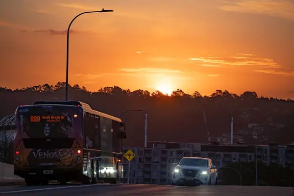 Akşam şehri gün batımında ufuk çizgisi, otoyol köprüsünden manzara, Albany, Auckland