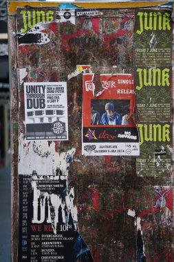 Auckland şehir merkezindeki Freyberg Meydanı yakınlarında eski yırtık posterli teknik bir standın desenli pejmürde yüzeyi.