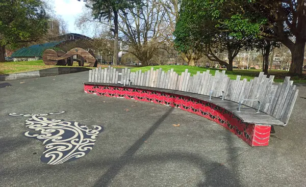 Victoria Park, Auckland 'da asfalt üzerinde balina şeklinde uzun bir bank ve Maori etnik grafiti..