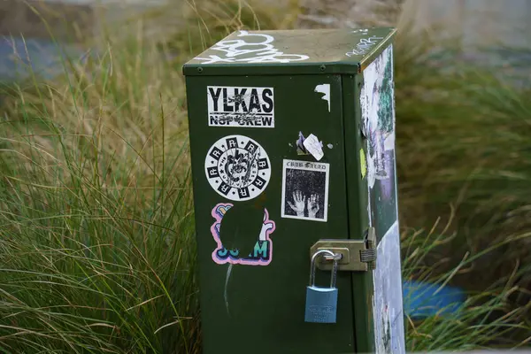 Auckland 'ın iş bölgesinin çimlerinde çıkartmaları olan bir teknik kabin.