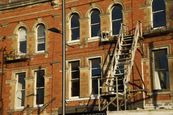 Karangahape rd caddesindeki kavisli pencereli ve harici demir merdivenli binanın kırmızı cephesi..