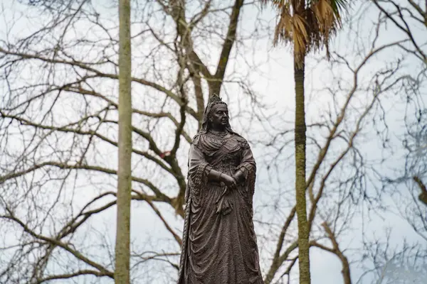 İngiliz Kraliçesi 'nin Albert Park, Auckland City' deki heykeli, palmiye ağaçlarıyla çevrili.