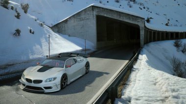 A sleek white sports car driving near a snow-covered mountain tunnel on a sunny winter day. clipart