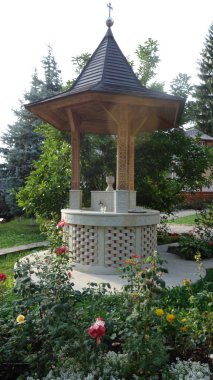 Güzel bahçe çardağı. Karmaşık oymalarla çevrili. Parlak çiçekler ve berrak bir gökyüzünün altında yemyeşil..