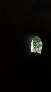 Karanlık bir mağaranın açılışından doğanın görüntüsü, ışık ve gölge arasındaki zıtlığı vurguluyor..