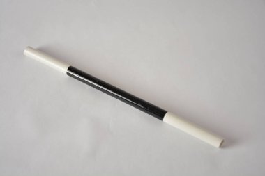 Sade bir yüzeyde parlak siyah beyaz bir sihirbaz değneği..