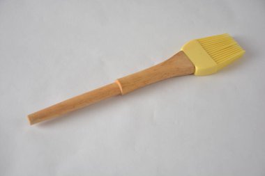 Beyaz arka planda tahta saplı silikon hamur fırçası.