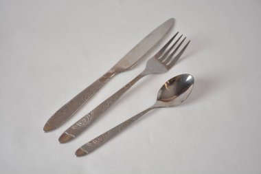 Zarif çatal, bıçak ve kaşık seti düz bir arka planda karmaşık desenlerle..