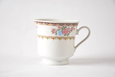 Sade bir arka planda çiçek desenli zarif porselen çay fincanı.