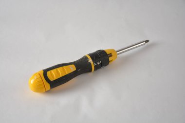 Sarı ve siyah tornavida düz bir arkaplan üzerinde değiştirilebilir bir kafa ile.