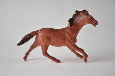 Dörtnala koşan kahverengi plastik at oyuncağı.