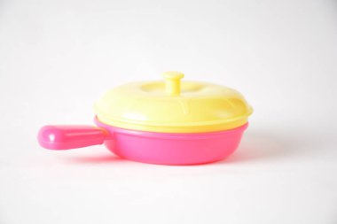 Pembe ve sarı renkli kapaklı parlak renkli oyuncak tavası.