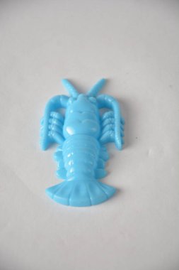 Bright blue plastic toy lobster against a plain white background. clipart