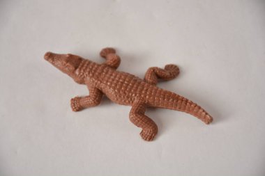 Sade beyaz arka planda kahverengi oyuncak timsah.