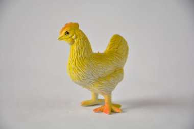 A small yellow plastic chicken toy with realistic features on a plain background. clipart