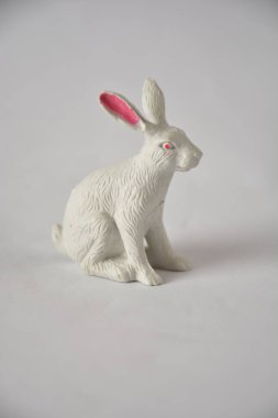 Pembe kulaklı beyaz tavşan heykeli sade bir zemine monte edilmiş..