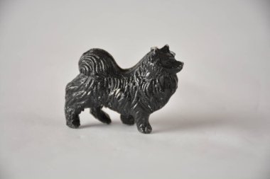 Small black Pomeranian figurine on a plain white background. clipart