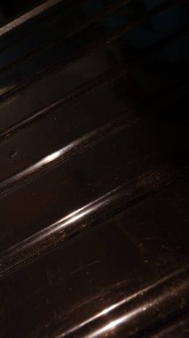 Yansıtıcı çizgileri olan desenli koyu bir yüzeye yakın plan.