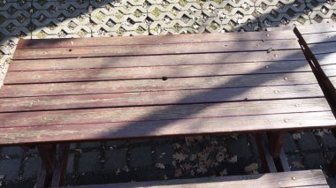 Güneş ışığında eskimiş ahşap piknik masası.