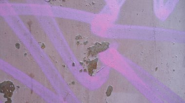 Yıpranmış beton duvara soyut pembe grafiti..