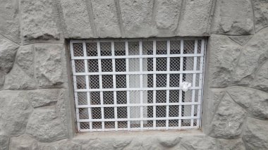 Taş bir binanın parmaklıklı penceresi.