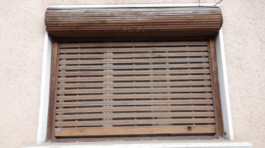 Kapalı ahşap pencere kapağı sıva duvarında..