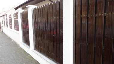 Beton direkli kahverengi ahşap çit.