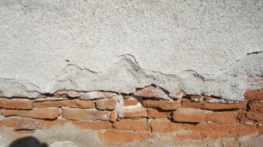 Alçı kabuğu soyulmuş eski tuğla duvar.