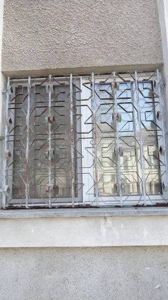 Metal çubukları ve yansımaları olan güvenli pencere