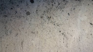 Koyu lekeli desenli beton yüzey.