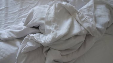 Buruşuk çarşaflı beyaz bir yatak..