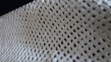 Örülmüş beyaz tekstil kumaşının yakın çekimi.