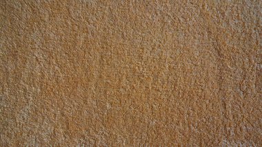 Kalıplı kahverengi kumaş yüzeyinin yakın çekimi.