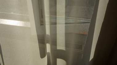 Perdelerin arasından süzülen güneş ışığı.