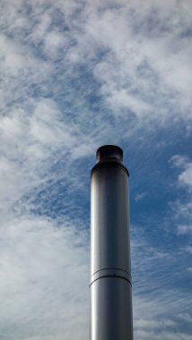 Bulutlu gökyüzüne karşı sanayi bacası.